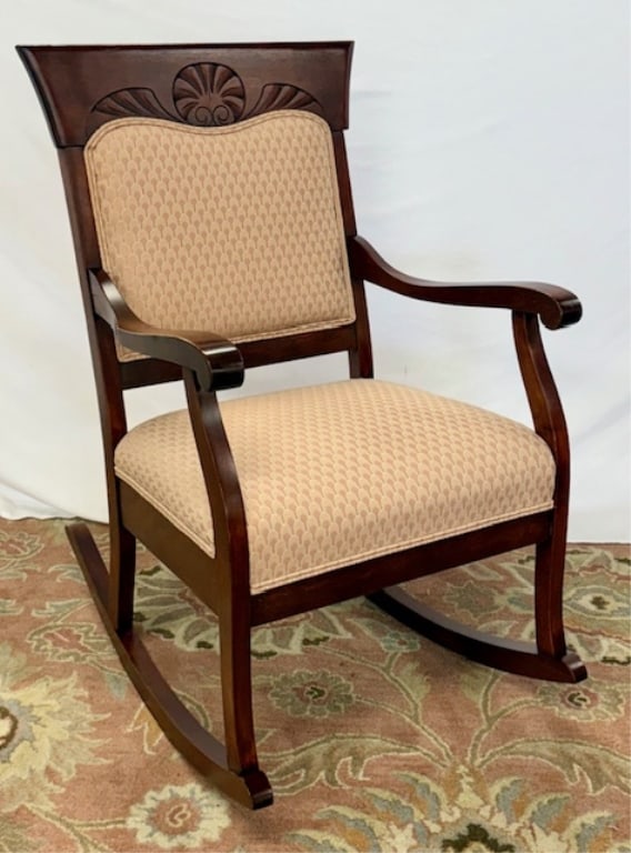 Vintage Carved & Upholstered Rocking Chair: Vintage carved rocking chair. Upholstered back and seat. Stained mahogany finish. Center carved shell detail. In excellent condition with minor scratches present. Approximately 37"h x 22.75"w x 32"d.