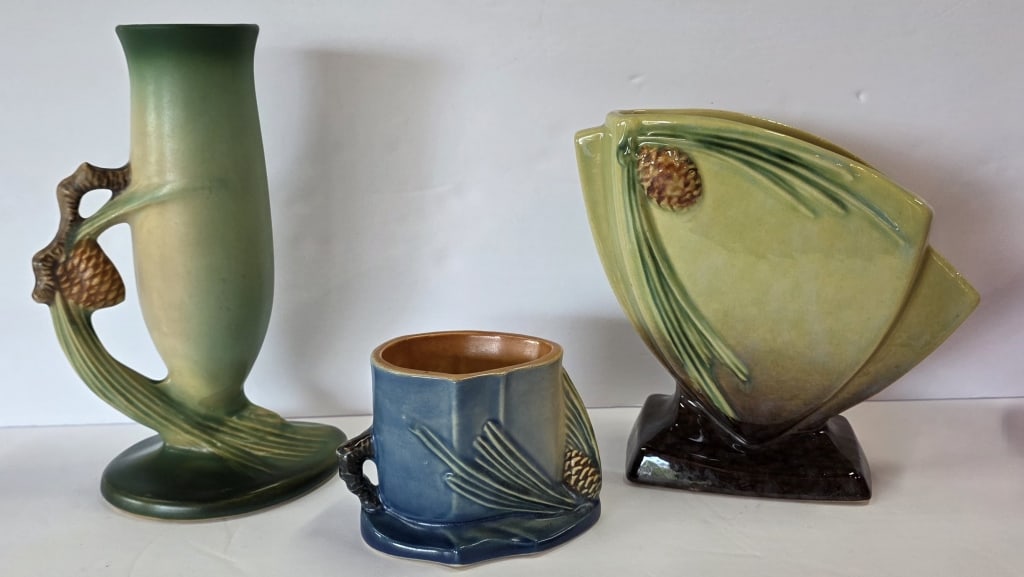 Vintage Roseville Pottery 'Pine Cone' Collectibles: Pair of vintage Roseville Pottery 'Pine Cone' collectibles. Includes pair of vases, #272 6.25"h Wincraft vase and #479 7.75"h bud vase, and 3"h match/cigarette holder, #498. 3 Total pieces. Photos are