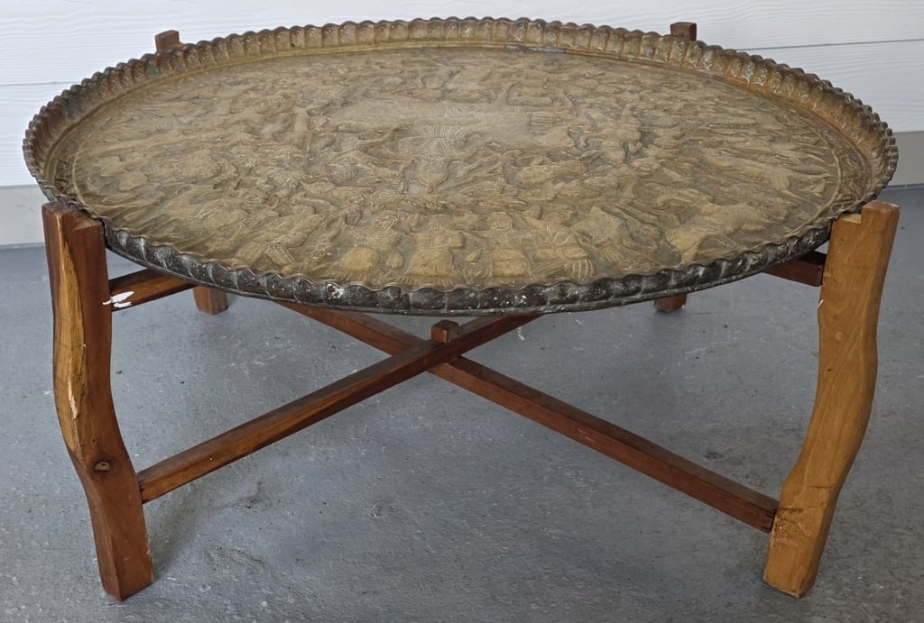Vintage Etched Moroccan Brass Tray Table: Vintage etched Moroccan brass tray table. Folding wood stand. Tray has hole for wall hanging. Base approximately 15"h x 36"w and tray 33.5"w. Photos are considered part of the condition and descriptio