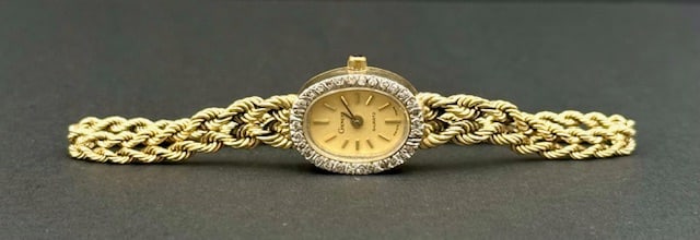 Ladies 14k Geneve Quartz Rope Watch: Ladies 14k Geneve Quartz wrist watch. Features diamond bezel and 14k yellow gold rope bracelet. Adjustable sizes. Serial #189263. Battery powered. Swiss made. Approximately 14g TW without movement. Ph