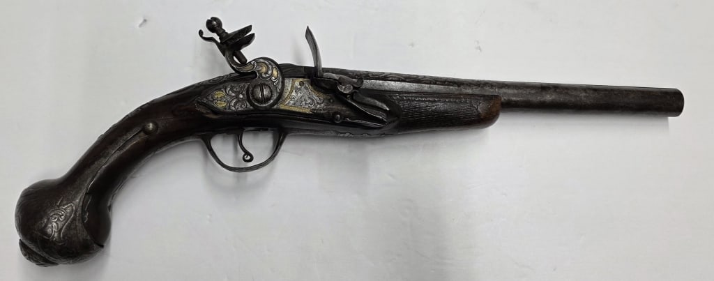 Antique Turkish Style Flintlock Pistol: Antique Turkish style flintlock pistol. Ornate, curved wooden grip with a distinct bulbous or "ball" butt. Top features possible makers mark. Some wood imperfections. In good condition for age. Approx