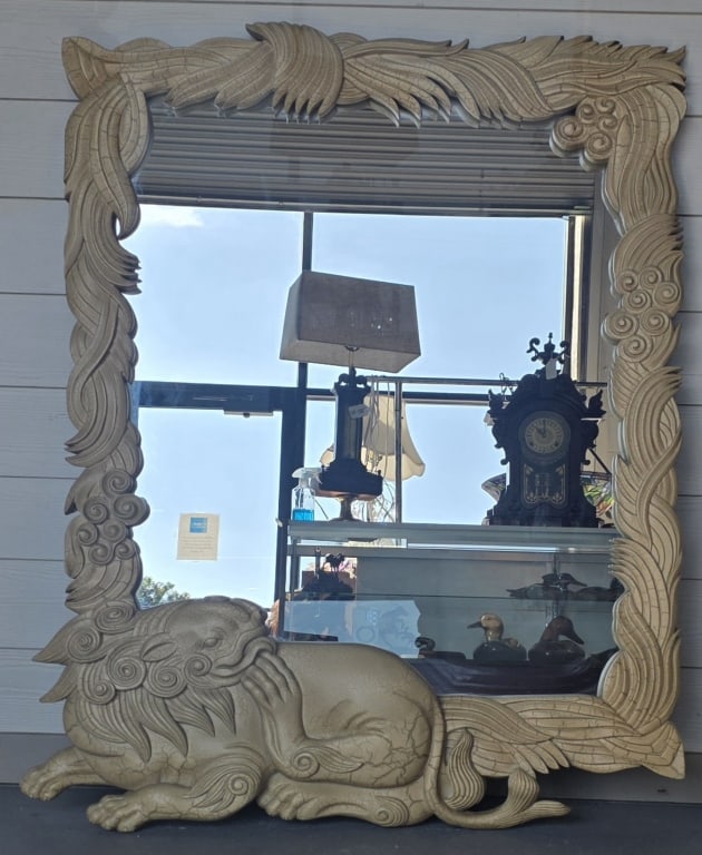 Vintage Foo Dog Framed Wall Mirror: Large vintage carved wooden mirror. Features a distressed white finish and intricate carvings including a foo dog. Approximately 51"h x 35"w. Chip on right back corner. Some small chips on edges. 