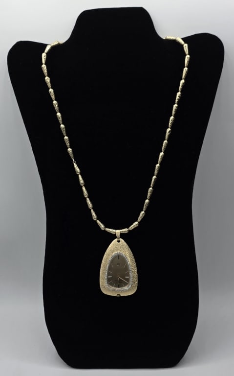 14k Bulova Pendant Watch on Chain 67.02g TW: 14k Yellow gold Bulova Accutron pendant watch on chain. Watch features diamond bezel and textured case. 14k 28" nugget design chain with box clasp and latch. Chain approximately 34.28g and pendant app