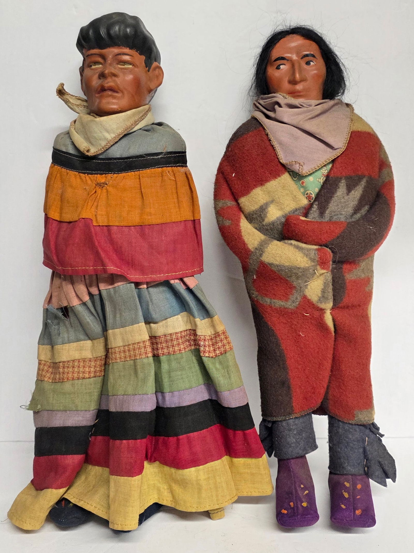 Pair of Vintage Native American Skookum Dolls: Pair of vintage Native Americans Skookum dolls. Dollsfeature vinyl heads with painted faces and are wrapped in blankets and fabric clothing. Soft bodies & wood legs. Approximately 14"long. Photos are