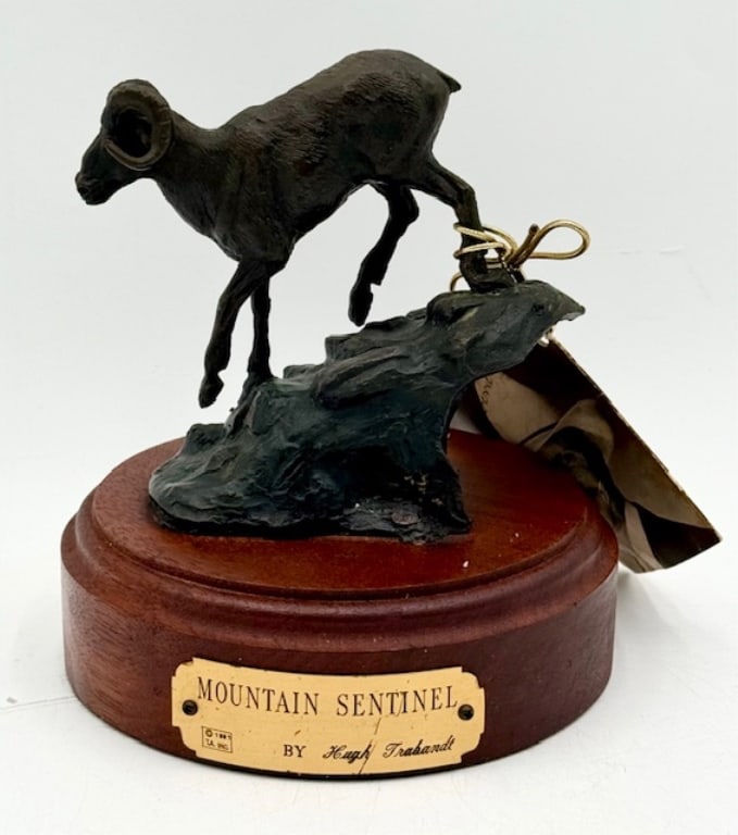 Hugh Trabandt 'Mountain Sentinel' Bronze Statue: Hugh Trabandt 'Mountain Sentinel' small bronze statue. Features bighorn sheep on a mountain. Signed. Mounted on wood base. Approximately 6.25"h x 5.5"w. Photos are considered part of the condition and
