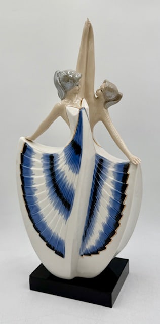 Josef Lorenzl Style Porcelain Dancers Figurine: Josef Lorenzl style porcelain figurine. Figurine depicts two dancers in a dynamic pose with arms raised and their dresses featuring a distinctive blue and black fan pattern. Mounted on wood base. In e