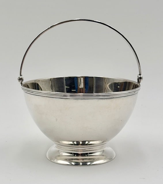 Tiffany & Co. Sterling Silver Sugar Basket 7.45oz: Tiffany & Co. sterling silver swing handle sugar bowl. Features swing handle and footed pedestal base. Approximately 5.25"h with handle and 7.45oz. Photos are considered part of the condition and desc