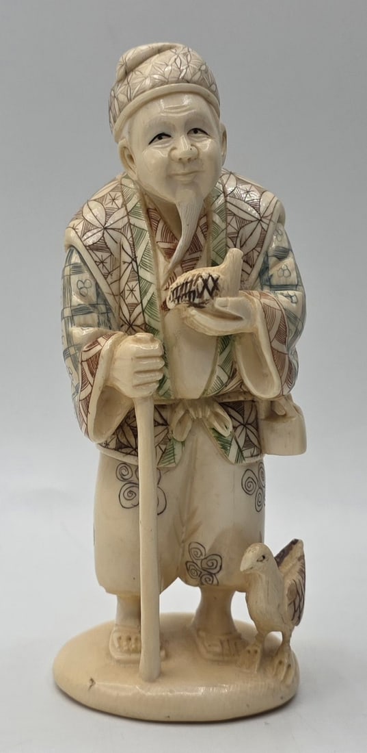 Vintage Japanese Okimono Carving: Vintage Japanese Okimono carving. Figurine carved from believed to be bone like material. The carving depicts an old man holding a staff and a chicken. Highly detailed with polychrome highlights. Stam