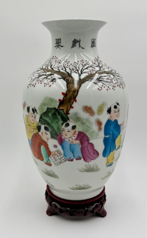Chinese Famille Rose Eggshell Porcelain Vase: Vintage Chinese famille rose "eggshell" porcelain vase. Features a hand painted scene of boys playing games against a stylized tree and rocky landscape background. Signed on bottom. Separate wooden st