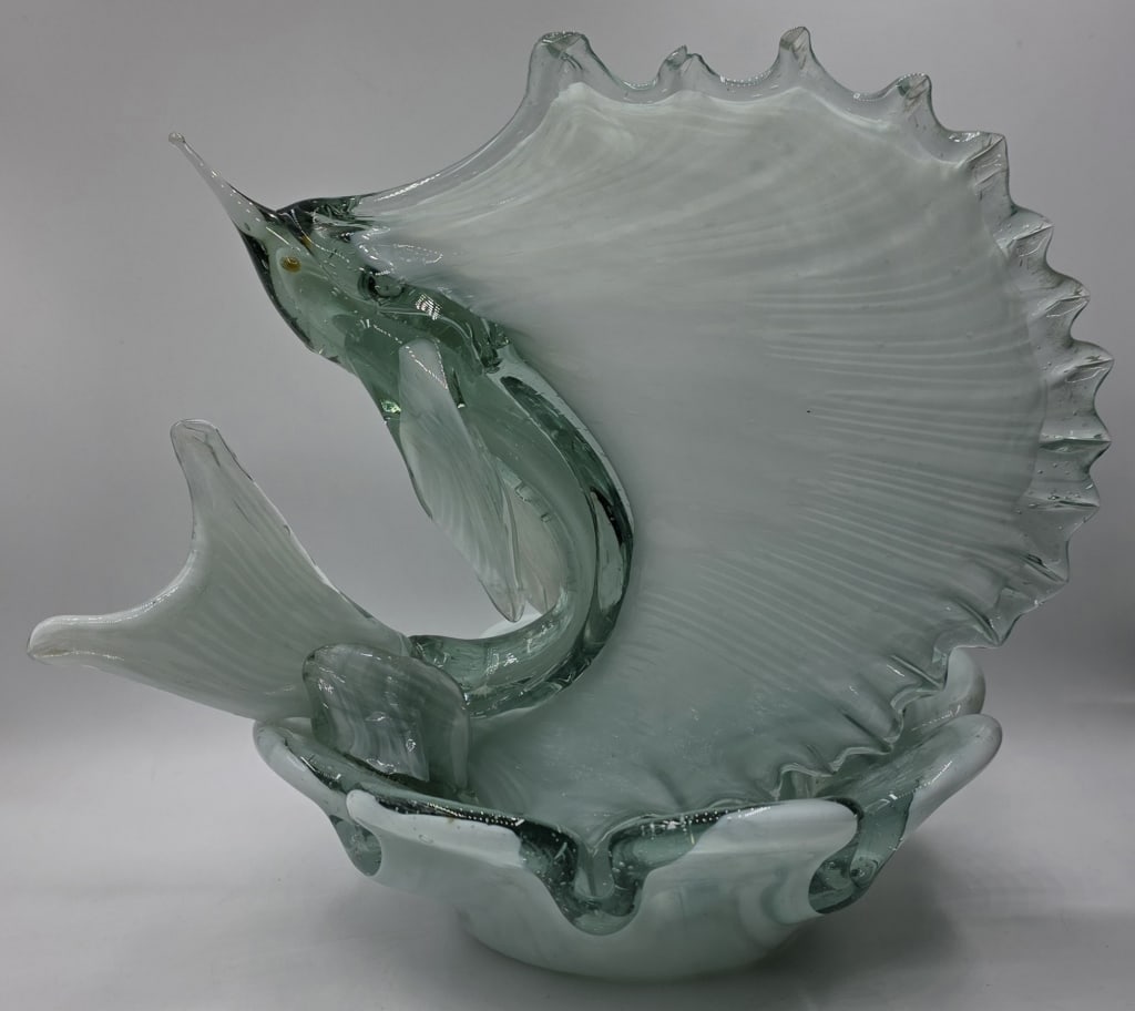 MCM Murano Style Art Glass Sailfish Sculpture: MCM Murano style hand blown art glass sailfish sculpture. Features a leaping sea green sailfish/swordfish attached to a shallow dish. Small nick present on one fin. Approximately 9"h x 9"dia.