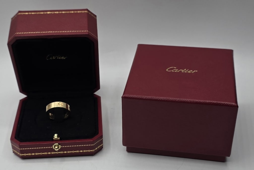 Cartier 18k Yellow Gold Classic Love Ring - 6.54g: Cartier 18k yellow gold classic LOVE band. Features the distinctive screw motif engraved around the exterior of the band. Inside engraved with serial number 182CPB. Size 57 (8.5). 5.5mm Width. With bo