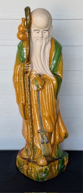 34" Chinese Mudman Shou Xing Statue: Vintage Chinese mudman figurine depicting Shou Xing. Hand crafted from clay and glazed in traditional green and yellow colors. Head left unglazed. Small natural crack line present on bottom. No