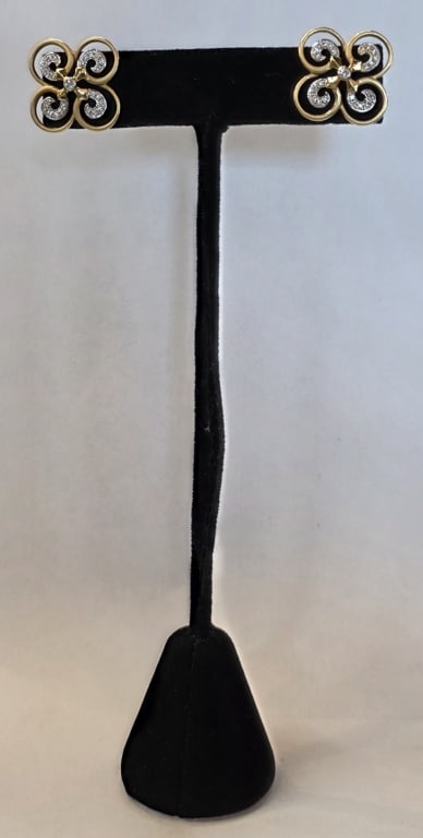 18k Diamond Twist Clover Stud Earrings 6.05g CTW: Pair of beautiful 18k gold and diamond twist clover stud earrings. Earrings feature open clover "twist" designs with diamonds set in white gold. Backs do not match. One marked 18k. Approximately 7/8"