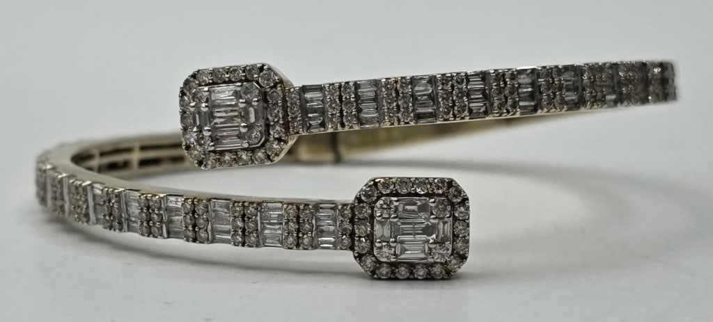 Beautiful 10k Diamond Cuff Bracelet 17.35g TW: Beautiful 10k gold diamond cuff bracelet. Bracelet features both round and baguette cut diamonds. Hinged open and close. Hinge needs service. Marked DD. Approximately 2.25"ID and 17.35g TW.