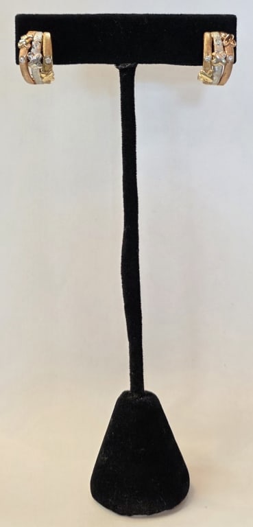 14k Tri Tone Stacked Diamond Earrings 6.55g CTW: Pair of 14k tri tone stacked diamond earrings. Earrings feature a textured finish with small round cut diamonds and raised "X" motifs layered over multi-tone bands. Hinged omega clasp closure. Approxi