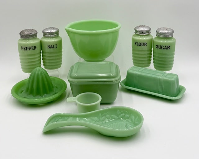 Assorted Vintage Jadite Kitchen Accessories: Large collection of assorted vintage jadite kitchen accessories. 10 Total pieces. Includes 4 5" shakers, chip present on one bottom and all tops dented, 3.5" x 5.25" covered dish, 2.5" x 6.5"