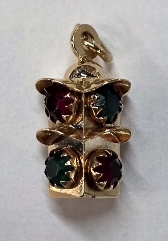 18k Traffic Signal Charm Pendant - 3.45g TW: 18k Yellow gold traffic signal light charm pendant. Features four sides set with red and green stones. Approximately 1" x .5" and 3.45g TW. Photos are considered part of the condition and