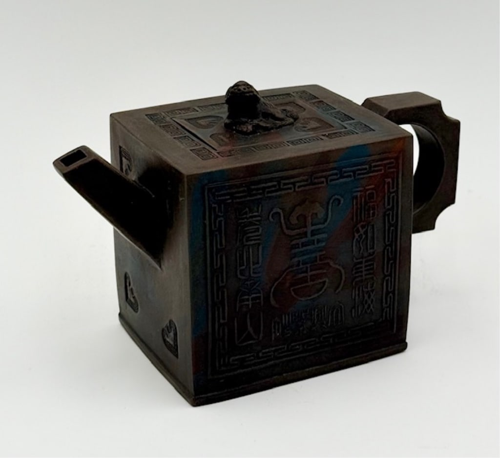 Chinese Yixing Zisha Teapot: Chinese Yixing Zisha Teapot. Handmade From Traditional Black Clay. The Surface Features Raised Symbols And Chinese Calligraphy. The Lid Includes A Small Foo Dog For The Handle. Approximately
