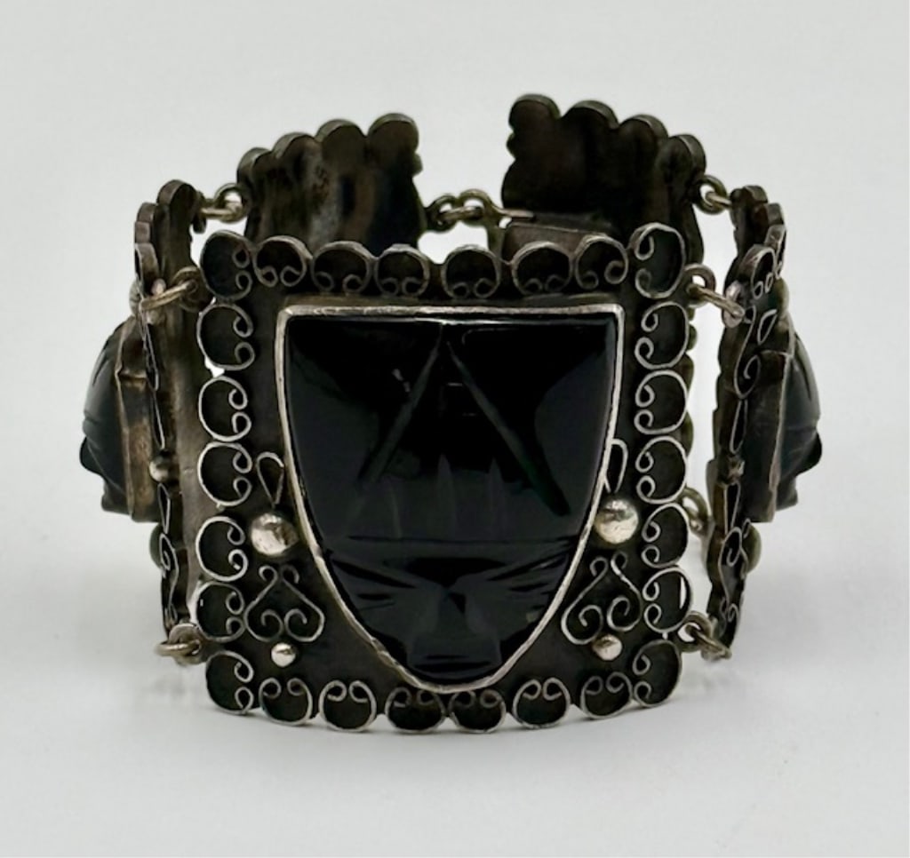 Sterling and Black Onyx Bracelet - 65.1g TW: Vintage Mexican sterling silver and black onyx bracelet. Mid century modern bracelet features carved black onyx Aztec masks set in ornate filigree silver panels connected by links. Approximately