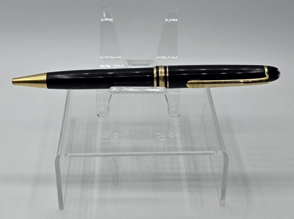 Montblanc Meisterstuck Classique Ballpoint Pen: Montblanc Meisterstuck Classique ballpoint pen. Featuring a black precious resin body with gold plated detailing and a white star emblem on the cap. Made in Germany. Marked AD253898. Approximately 5.5