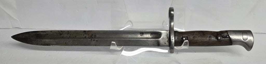 Vintage Spanish M1943 Mauser Bayonet: Vintage Spanish M1943 Mauser bayonet. Wooden handle. Blade and muzzle ring have several marks present including 8569, 4,0. Approximately 15" long. Photos are considered part of the condition and