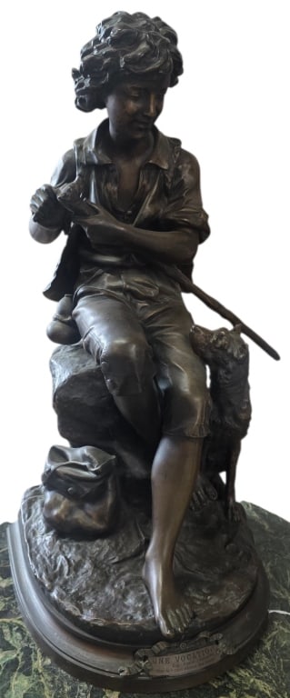 Bronze "Une Vocation" Sculpture after Aizelin: "Une Vocation" bronze sculpture by artist Eug?ne-Antoine Aizelin. Depicts a young shepherd boy sitting on a rock carving a walking stick. Approximately 20"h. Photos are considered part of the