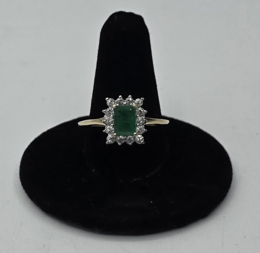 14k Emerald Ring - 3.2g TW: 14k Emerald ring. 3.2 g TW. Emerald cut emerald surrounded by prong set white sapphires set in 14k yellow gold. Size 10 3/4. Photos are considered part of the description and condition. R