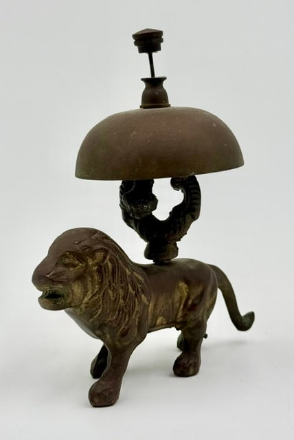 Vintage Solid Brass Lion Desk Bell: Vintage solid brass lion desk bell. Features a standing lion figure acting as the base, holding a bell overhead with a push button mechanism on top. In good condition for age. Approximately 5.25"h x 2