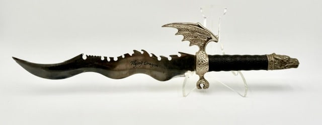 Flying Dragon Fantasy Dagger: Flying Dragon fantasy dagger. It features a stainless steel, rippled (wavy) blade and serrated top edge with "teeth" along the spine. Dragon wing shaped guard and detailed dragon head pommel. Made in 