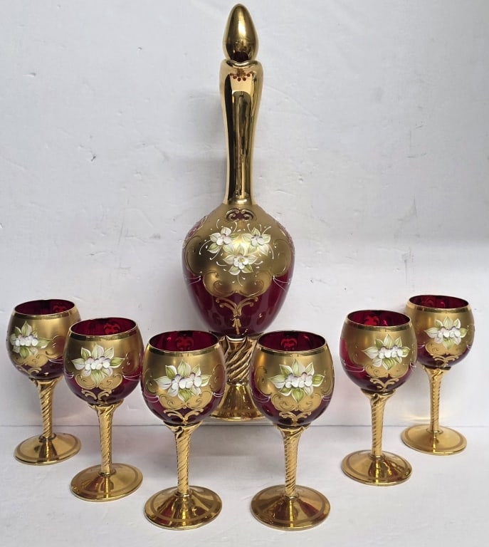 Vtg. Murano "Tre Fuochi" Venetian Decanter Set: Vintage Murano "Tre Fuochi" Venetian ruby red glass decanter set. Set features hand painted floral enamel work and 24kt gold leaf accents. Set includes 16" decanter with topper and (6) 6" goblets. All