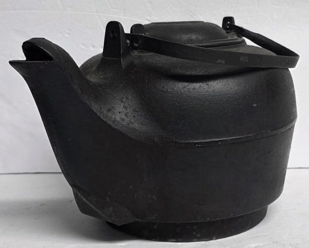 Antique Cast Iron Kettle: Antique cast iron kettle. Features a swing lid with a swivel mechanism and a bail handle. Unmarked. Approximately 9"h. Photos are considered part of the condition and description. 508