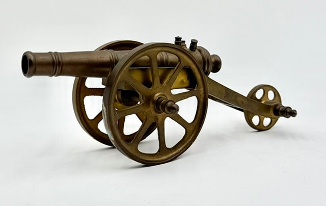 Vintage Brass Table Top Cannon: Vintage brass table top cannon. Made of solid brass with turning wheels. Some patina present. Approximately 4"h x 10.25"l x 4.5"w. Photos are considered part of the condition and description. 802-16