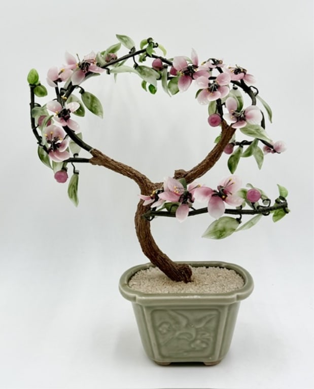Chinese Art Glass & Jade Bonsai Tree: Chinese art glass and jade bonsai tree. Tree features delicate pink cherry blossom petals and green leaves handcrafted from polished jade stones. Set inside a traditional light green celadon ceramic p
