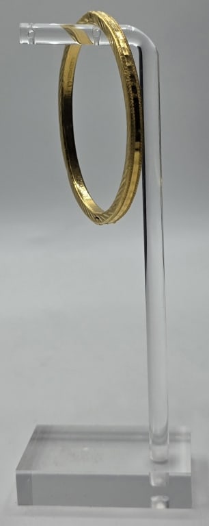 24k Bangle Bracelet - 15.37g: 24k Bangle bracelet. Etched design on top and bottom. Polished tile look design on front with textured trim. Box clasp with safety latch and hinge. 15.37g. Approx. 2.5"L x 2"W. Photos are considered p