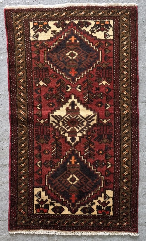 Hand Knotted Persian Wool Rug: Hand Knotted Persian wool rug. Featuring traditional red and black geometric medallions. Approximately 48"h x 26.5"w. Photos are considered part of the condition and description. 307