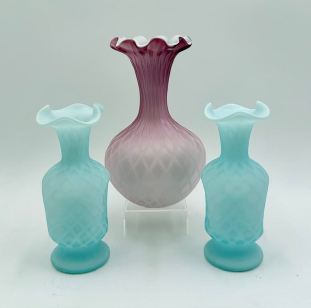 3pc Cased Satin Glass Diamond Quilt Vases: 3pc Collection of vintage cased satin vases featuring the diamond quilt pattern. Includes 8.75" cranberry vase and pair of 7.5" Fenton style blue vases. In good condition with no chips or cracks, some