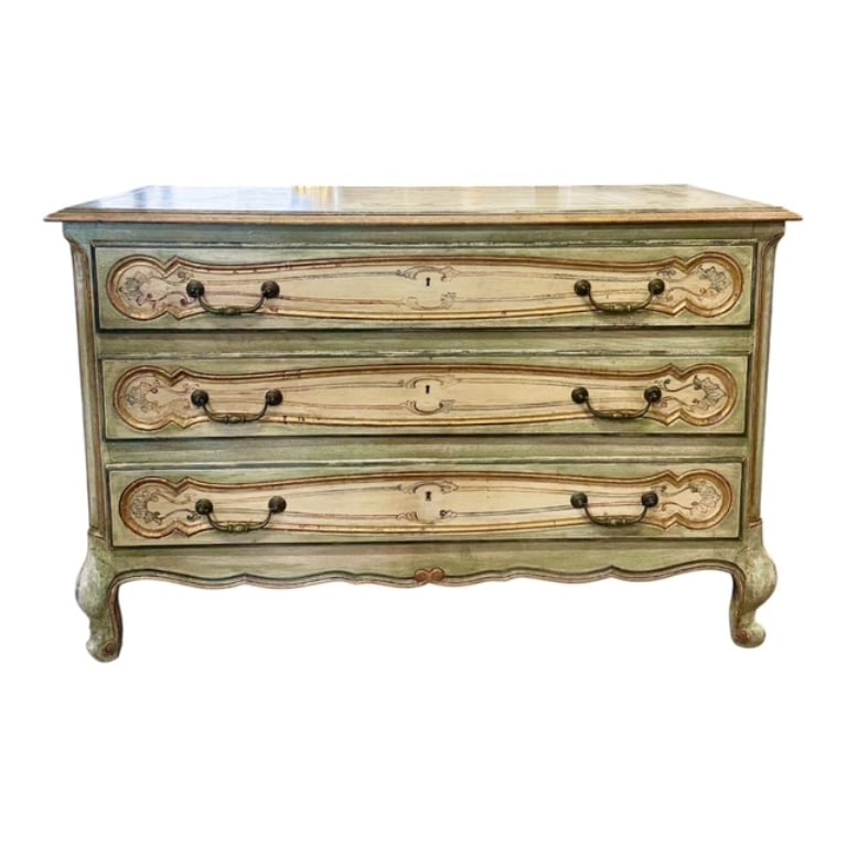 French Louis XV Style Distressed Commode: French Louis XV style painted commode. 3 Drawer commode features distressed, pastel green paint base accented with gold leaf detailing around the panel carvings. Equipped with ornate antiqued bronze d