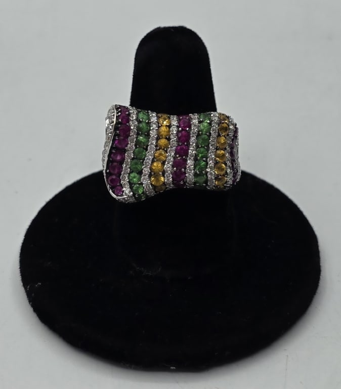 18k Multicolor Gemstone Cocktail Ring - 10.09g TW: 18k White gold multicolor gemstone cocktail ring. Features vertical rows of round cut multicolored stones separated by thin rows of accent diamonds all set in white gold. 10.09g TW. Size 7.5. Approx. 