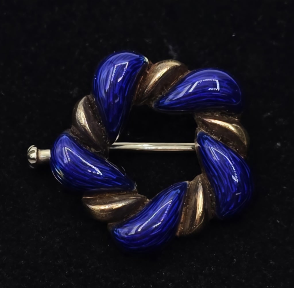 Vintage 18k Blue Enamel Brooch - 7.24g TW: Vintage 18k blue enamel wreath brooch. 7.24g TW. Features alternating yellow gold and blue enamel twisted design. Marked 750. Trombone pin closure. Approx. 0.75" x 0.75". Some enamel missing/worn off 