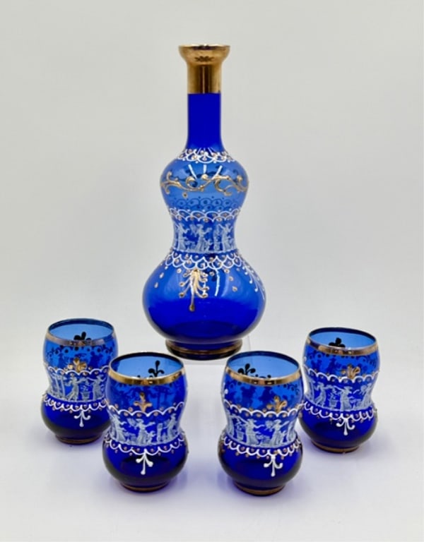 Beautiful Venetian Cobalt Blue Decanter Liquor Set: Beautiful Venetian cobalt blue glass decanter liquor set. Hand blown set features hand painted white enamel figures and 24k gold trim. Includes 10.5" decanter with no stopper and four 4" cups. In good