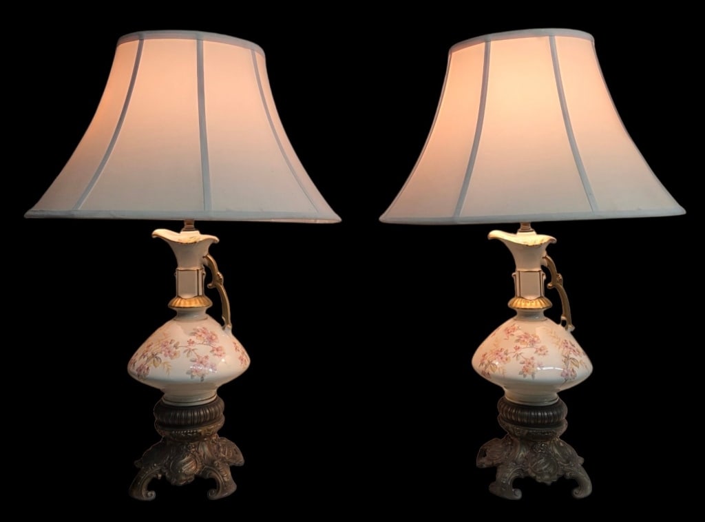 Pr. Vintage Victorian Style Urn Table Lamps: Pair of Victorian style urn table lamps. Made of porcelain and adorned with delicate pink floral patterns and scrolling gold accents. Multi footed brass base. In working condition. Approximately