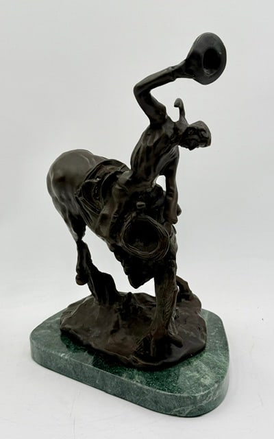 C.M. Russell "The Bucker and the Buckeroo": C.M. Russell "The Bucker and the Buckeroo" bronze sculpture. Reproduction bronze depicts a dynamic bucking horse and rider with a hat raised in his right hand. Mounted on a polished green marble base.