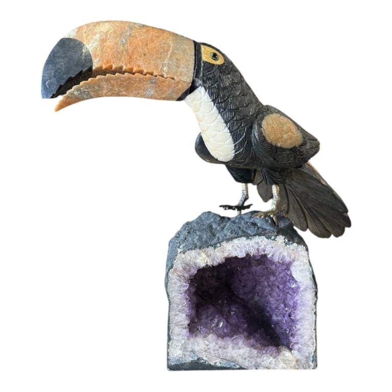 Carved Gemstone Toucan on Amethyst Geode: Stunning carved toucan on amethyst geode base. Toucan body carved from polished black onyx or obsidian and beak sculpted from a contrasting orange calcite, jasper, or agate. Mounted securely via metal