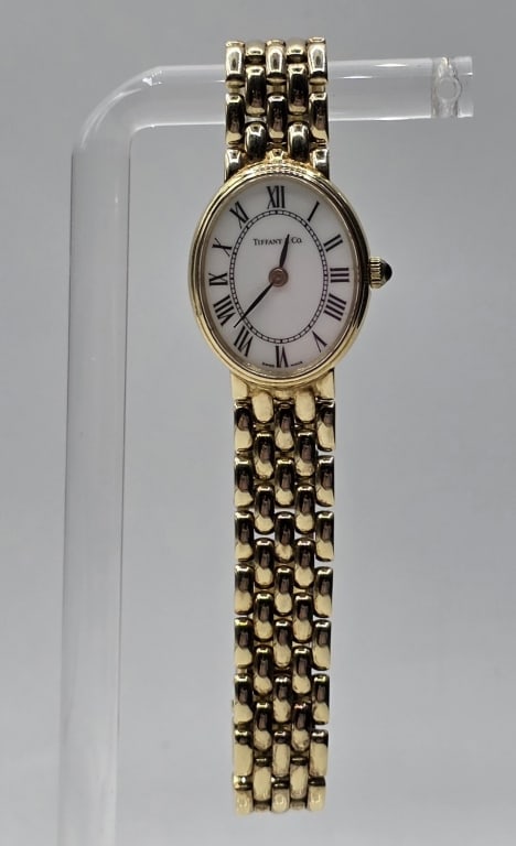 Tiffany & Co. Classic 14K Gold Ladies Watch 28g: Tiffany & Co. classic oval 14K yellow gold ladies watch. Features a white oval dial detailed with black Roman numeral hour markers and matching slim hands. Constructed with a solid 14K yellow gold cas