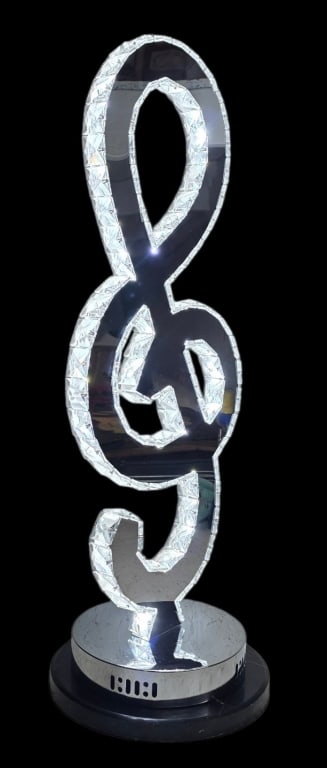 Unique Crystal Treble Clef LED Table Lamp: Unique crystal treble clef LED table lamp. Features a stylized musical G clef composed of textured faux crystals embedded with internal LEDs, sitting on a chrome finished circular metal base. In
