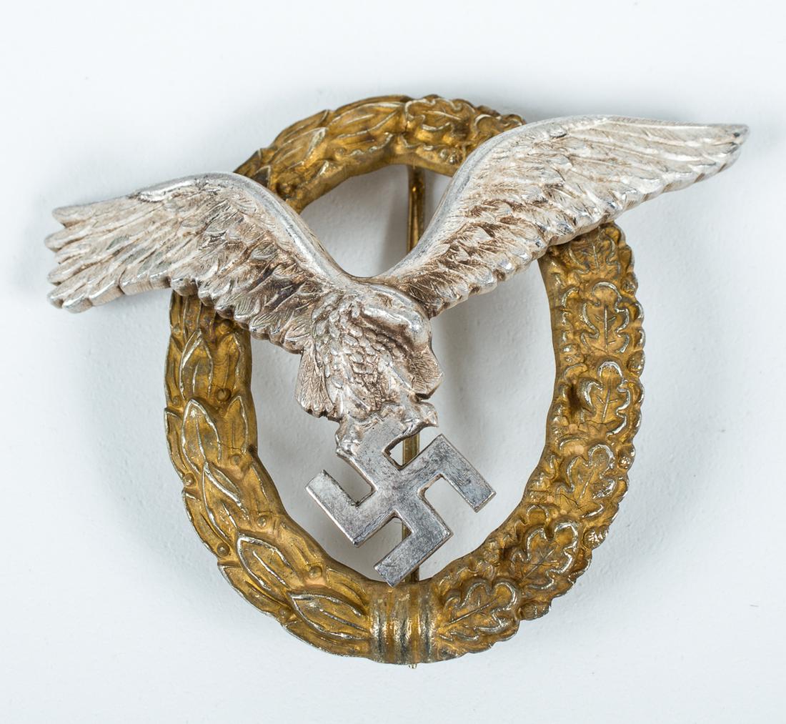 WWII GERMAN LUFTWAFFE PILOT'S BADGE C. E. JUNCKER: Luftwaffe Pilot's badge by C. E. Juncker. The pilot badge features a swooping eagle clutching a mobile swastika in itâ€™s talons. The eagle is superimposed on a wreath of half laurel and half oak