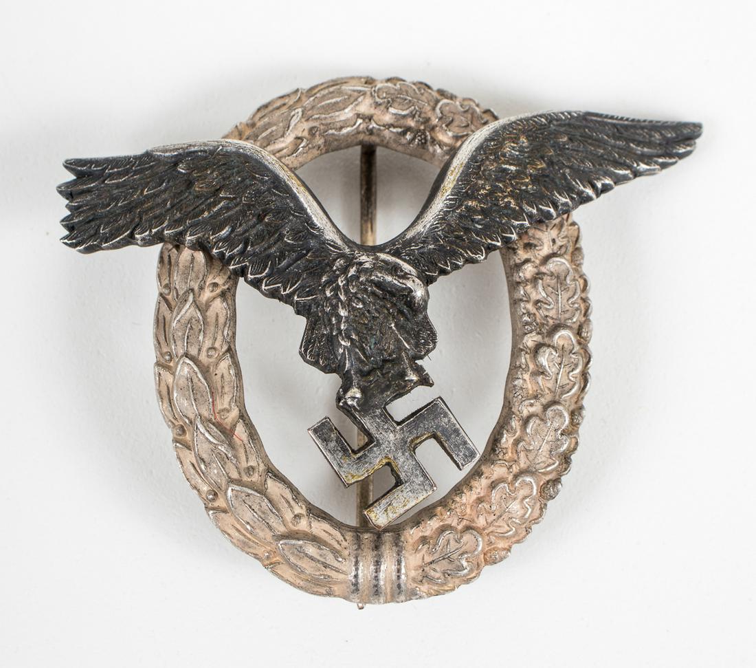 WWII GERMAN LUFTWAFFE PILOT'S BADGE DEUTSCHBEIN: Luftwaffe Pilot's badge by Deutschbein. The pilot badge features a swooping eagle clutching a mobile swastika in itâ€™s talons. The eagle is superimposed on a wreath of half laurel and half oak l