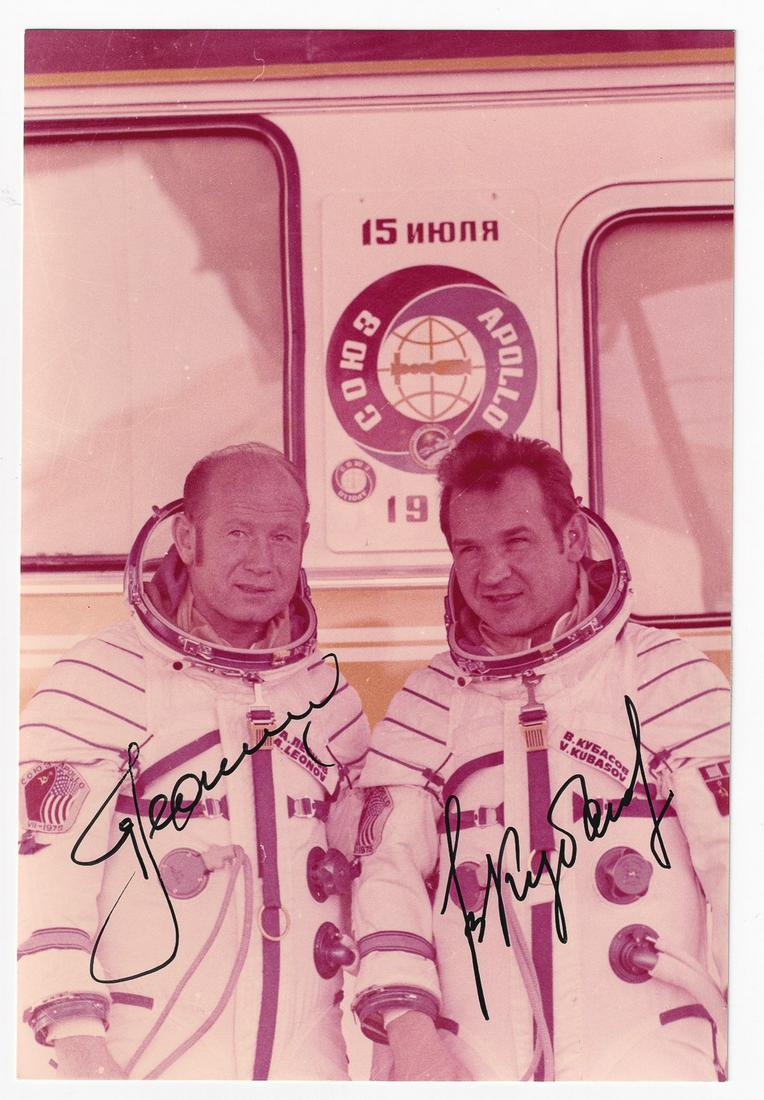 LEONOV & KUBASOV SIGNED PHOTO: A color photograph signed by cosmonauts Alexei Leonov and Valery Kubasov, the Russian crew members of the Apollo-Soyuz mission, 4.25 x 6.25 inches, in good condition.