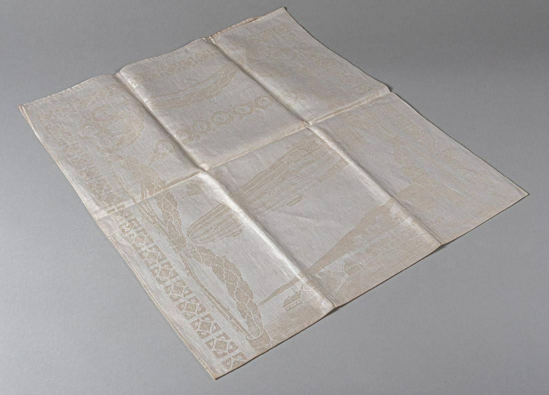 ZEPPELIN TABLE CLOTH: Antique Zeppelin table linen, images woven in the fabric on both sides. A Zeppelin in flight above a village and on the opposite side three farmers waving at the Zeppelin and reading 'Deutschland vora