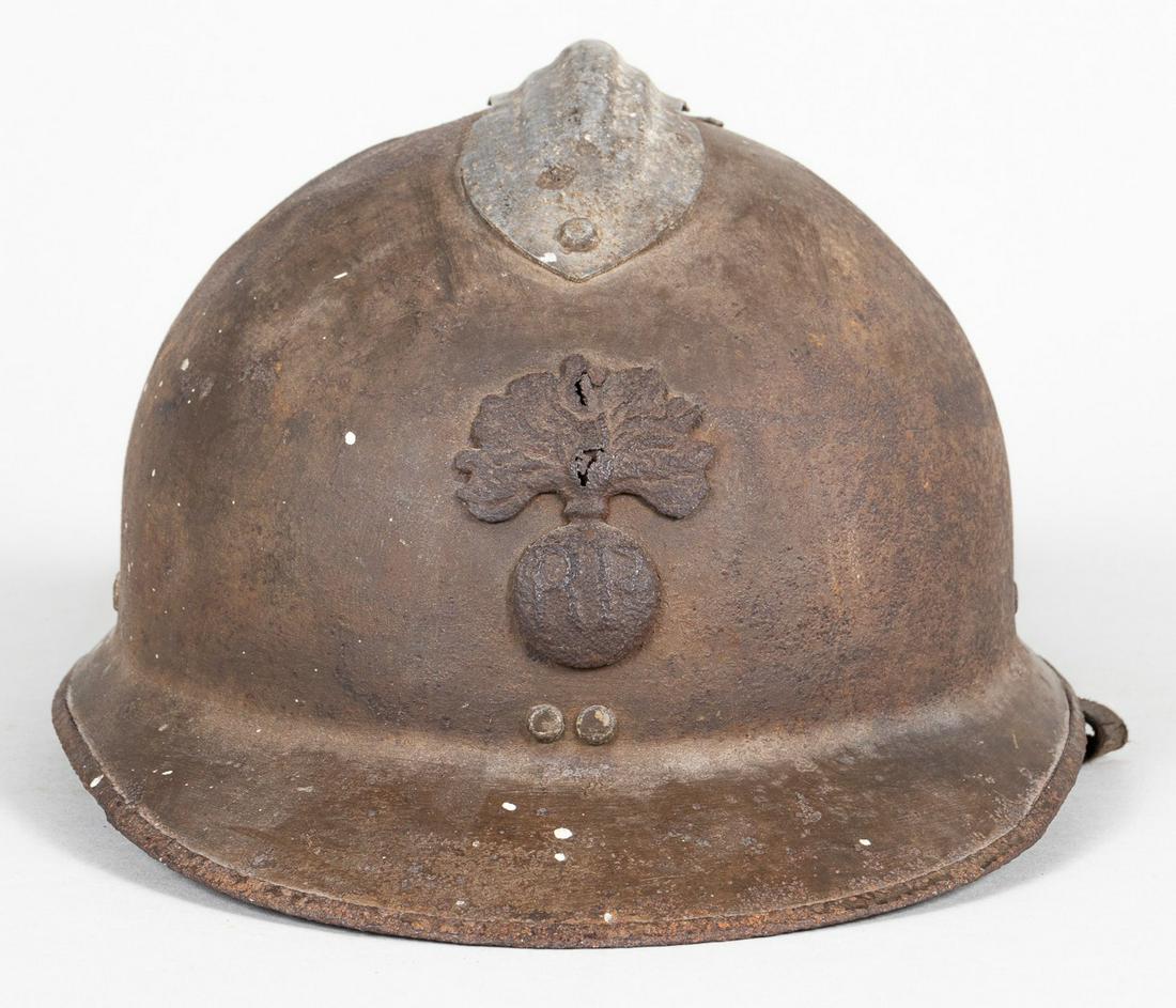 WWI FRENCH ADRIAN HELMET WITH INFANTRY PLATE: WWI French Adrian helmet with a flaming bomb metal insignia for infantry and the French Republic initials 'RF', the chinstrap leather is dried out, the interior shows rust but has four liner attachmen